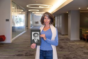 Melinda Low Pampallona ’88 with portrait of her father Dr. Myron Low,faculty member (deceased)