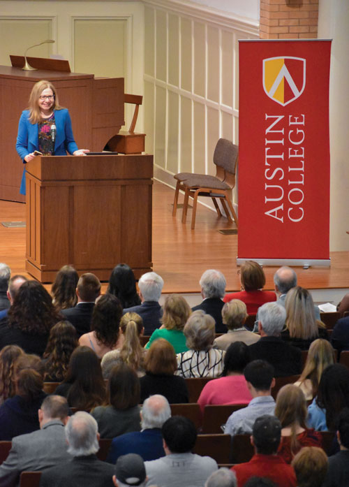 Vertical view of crowd facing Dr. Katharine Hayhoe as she speaks behind a podium in Wynne Chapel